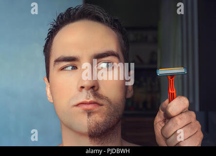 Ein Mann rasiert sein Gesicht ohne Creme oder Schaum, Schmerzen und Leiden. Die Hälfte Gesicht rasiert Halb überwachsen mit einer dicken Bart. Stockfoto