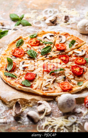 Frische italienische Pizza mit Pilzen Tomaten und Käse, in der Nähe Stockfoto