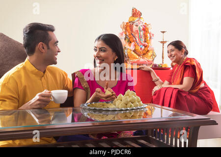 Mann Frau zusammen zu sitzen, während Frau modaks und Mutter und Recht Uhren macht Stockfoto