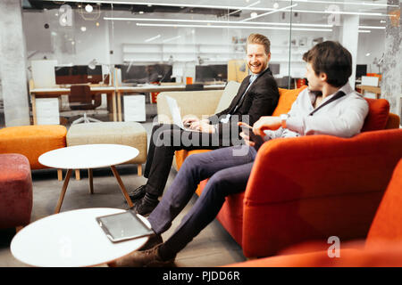 Geschäftsleute arbeiten an Geräten suchen Stockfoto