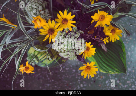 Blumenstrauß aus wilden Blumen auf inmitten der Marmorboden im Innenraum. Getönte instagram Fotos Stockfoto