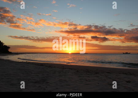 Sonnenuntergang über dem Strand am Inskip Point, nach Fraser Island suchen wie ein Boot in der Nähe des Horizonts. Stockfoto