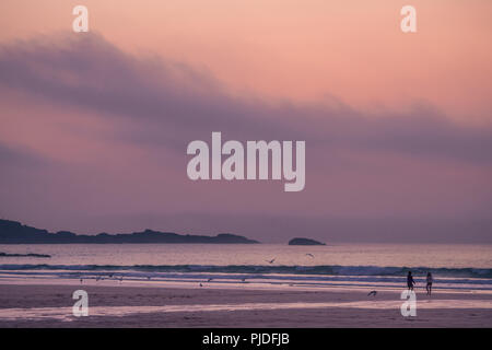 St. Ives, England - Mai 2018: die Familie zu Fuß auf den leeren schöne Porthmeor Beach bei Sonnenuntergang, Cornwall, Großbritannien Stockfoto