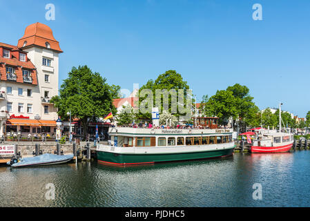 Rostock, Deutschland - 26. Mai 2017: Bunte Hafenrundfahrt Schiff und Fischerboote in der ruhigen Kanal ruht auf diesen Frühling heißen Tag in Warnemünde, Rosto Stockfoto