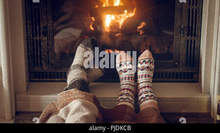 Getönten closeup Bild von Familie tragen warmen gestrickten Socken am Kamin Haus liegen Stockfoto