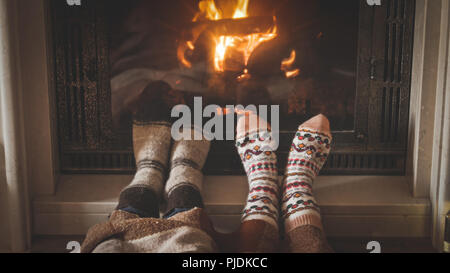 Getönten closeup Bild von Mann und Frau in Wollsocken und Lügen durch den Kamin Stockfoto