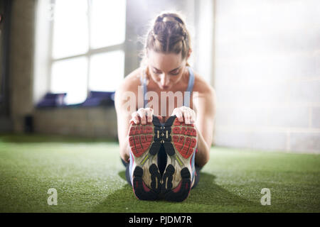 Frau, die stretching-Übung im Fitnessstudio zu tun Stockfoto