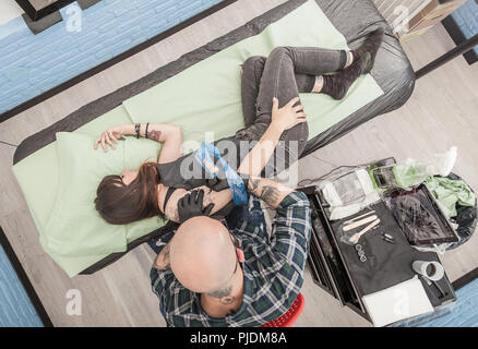 Tätowierer Zeichnung auf dem Arm des Client Stockfoto