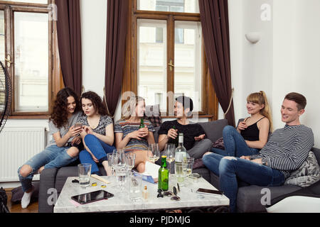 Gruppe von männlichen und weiblichen Erwachsenen Freunde auf dem Sofa sitzen, plaudern und Trinken Stockfoto