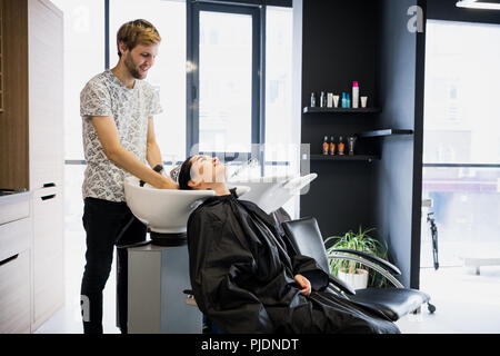 Schöne junge Mädchen waschen ihren Kopf in einen Schönheitssalon Stockfoto