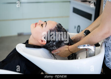 Schöne brünette Mädchen waschen Sie Ihr Haar in der Friseur Stockfoto