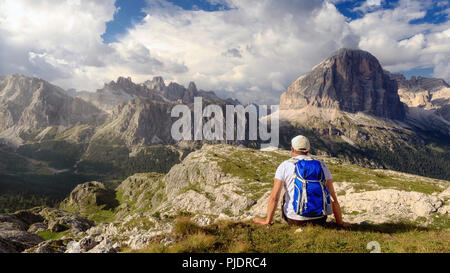 In der wunderschönen alpinen Landschaft eingebettet, ein Mann bewundert die hochalpine Landschaft mit Bergen und bewölktem Himmel. Stockfoto