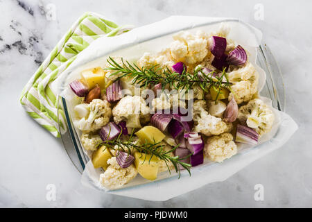 Herbst Gemüse im Glas Backblech: Blumenkohl, Kartoffeln und rote Zwiebeln. gesund essen im Ofen gebacken. Stockfoto