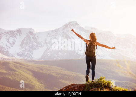 Frau steht Big Rock gegen Berge Stockfoto