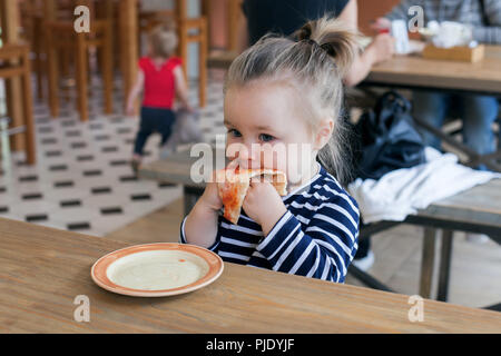 Süße kleine 2 Jahre Mädchen essen Pizza im Restaurant Stockfoto