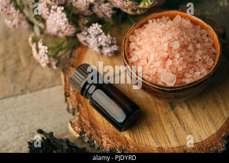 Herbst Spa- und Aromatherapie, Herbst spa Still life Wellness Konzept. Sortiment an ätherischen Öl, Meersalz, Kerzen Trocken Blumen und Kegel Stockfoto