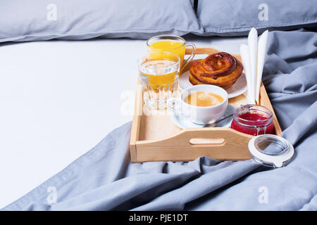 Frühstück Bed Holz- Fach/Bun graue Handtücher Bettwäsche Laken Kissen Bettdecke Hotel Zimmer am frühen Morgen im Hotel Hintergrund Konzept Innenraum Stockfoto