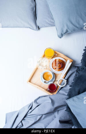 Frühstück Bed Holz- Fach/Bun graue Handtücher Bettwäsche Laken Kissen Bettdecke Hotel Zimmer am frühen Morgen im Hotel Hintergrund Konzept innere Kopie Spac Stockfoto