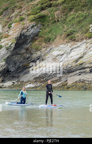 Urlauber auf Stand up paddleboards auf dem Fluss Gannel an Crantock in Newquay Cornwall. Stockfoto