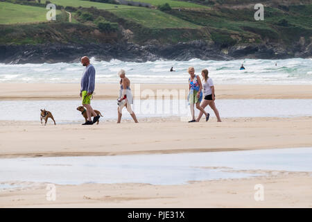 Eine Familie von Urlaubern und Ihren Hunden einen Spaziergang entlang der Küste bei Crantock Beach in Newquay Cornwall. Stockfoto