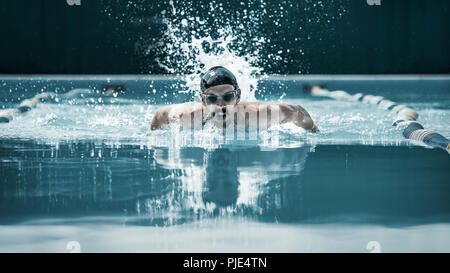 Die dynamische und Schwimmer in Gap Atmung Durchführung der Schmetterling am Pool. Der junge Mann. Das fitsport, Schwimmer, Pool, gesund, Lifestyle, Wettbewerb, Ausbildung, Athlet, Energiekonzept Stockfoto