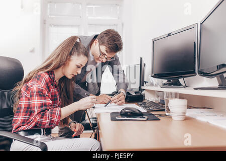 Junge smart Kollegen im Büro über die finanzielle Berichterstattung und neue Geschäftsideen. Stockfoto