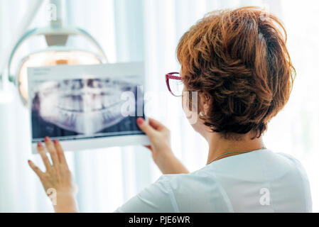 Ein Zahnarzt untersucht orthopantomogram in Ihren Händen Stockfoto