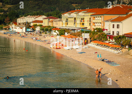 Die Menschen genießen den kleinen Strand am Hotel gesäumt Seaside Resort Village von Baska auf der kroatischen Insel Krk in der Adria Stockfoto