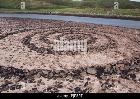 Ein großer Mann aus Spirale der Steine auf achnahaird Beach, Schottland, mit dem Fluss hinunter auf das Meer und die Hügel neben dem Strand Stockfoto