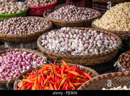 Körbe mit frischen lokal Bauernhof Gewürze wie Zwiebeln, Knoblauch, Paprika, Frühlingszwiebeln auf dem täglichen Markt in Hanoi, Vietnam Stockfoto