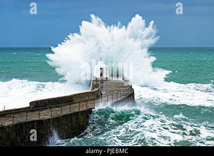 Atlantic Storm Wellen gegen die Hafenmauer an Portreath in Cornwall, England, Großbritannien, Großbritannien. Stockfoto