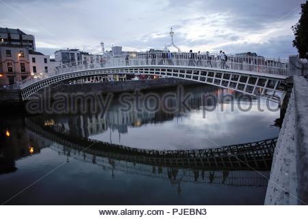 Abends Licht in den Himmel über dem ikonischen Ha'Penny Bridge, die den Fluss Liffey in Dublin, Irland kreuzt. Stockfoto