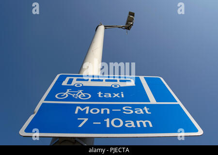 Britische blau-weißen Schild zeigt ein Bus und Taxi Lane mit Zeiten der Betrieb Stockfoto