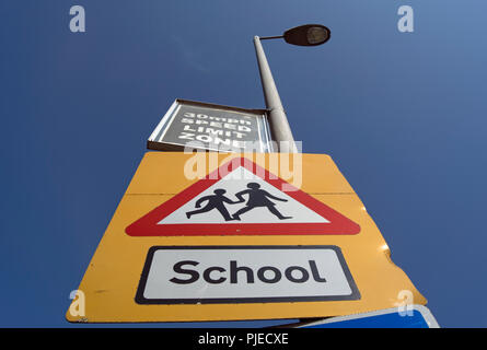 Britische Beschilderung eine Schule mit Kindern die Straße überqueren und einer 30-Km/h-Tempolimit, in Surbiton, Surrey, England Stockfoto