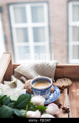 Romantische Kaffee in einer Tasse auf einem hölzernen Hintergrund mit einem Plaid, ein Blumenstrauß aus den weißen Rosen und im Herbst Gemütlichkeit. Guten Morgen. obere Ansicht. Kopieren Sie spase Stockfoto