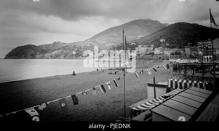 LEVANTE ITALIEN - 24. APRIL 2011; Mediterranean Seaside Beach Dorf unten Hügel mit charakteristischen Gebäude mit Menschen am Strand von Hi umgeben Stockfoto