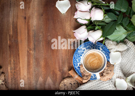 Romantische Kaffee in einer Tasse auf einem hölzernen Hintergrund mit einem Plaid, ein Blumenstrauß aus den weißen Rosen und im Herbst Gemütlichkeit. Guten Morgen. obere Ansicht. Kopieren Sie spase Stockfoto