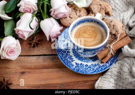 Romantische Kaffee in einer Tasse auf einem hölzernen Hintergrund mit einem Plaid, ein Blumenstrauß aus den weißen Rosen und im Herbst Gemütlichkeit. Guten Morgen. obere Ansicht. Kopieren Sie spase Stockfoto