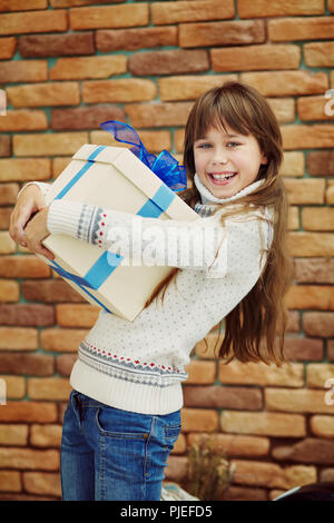Niedliche happy teenage Mädchen, dass eine Geschenkverpackung Stockfoto