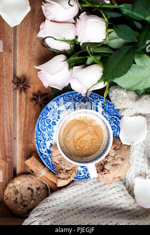 Romantische Kaffee in einer Tasse auf einem hölzernen Hintergrund mit einem Plaid, ein Blumenstrauß aus den weißen Rosen und im Herbst Gemütlichkeit. Guten Morgen. obere Ansicht. Kopieren Sie spase Stockfoto
