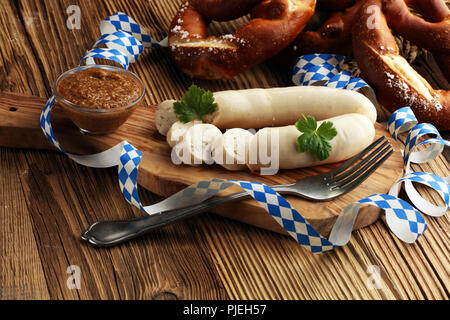 Weißwurst Frühstück mit Würstchen, weiche Brezel und Milder Senf auf Holzbrett aus Deutschland. Stockfoto