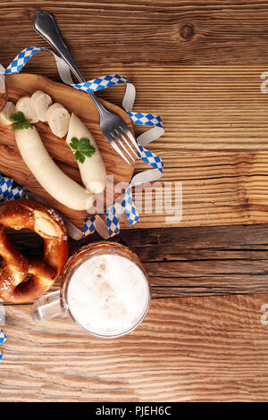 Weißwurst Frühstück mit Würstchen, weiche Brezel und Milder Senf auf Holzbrett aus Deutschland. Stockfoto