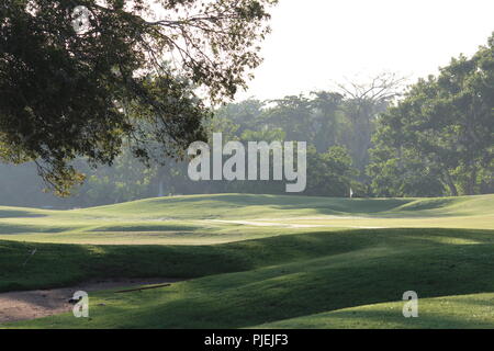 Morgen Sonne und Schatten über das 10. Loch an der Playa Dorada Golf Course, Teil von einem Sandfang in den Vordergrund, das Grün mit Flagge im Hintergrund Stockfoto