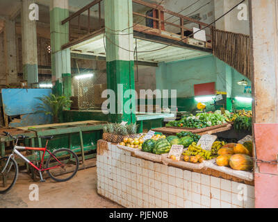 Ausblick auf den kleinen Markt für Obst und Gemüse in einem alten, verfallenen Gebäude mit grünen getragen Wände, kleine Auswahl und leere Regale in den Geschäften Stockfoto