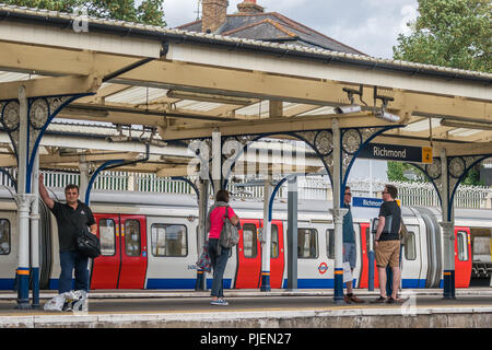 London, England - Juli 2018: Pendler warten auf ankommenden Zug auf dem U-Bahnhof in Richmond Stockfoto