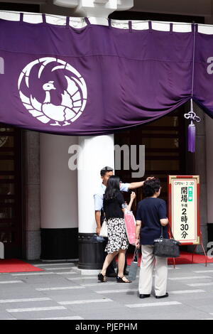 Blick auf die ginza's Kabuki-za Kabuki Theater, wo ein Arbeitnehmer Besucher hilft vor einem Vorhang mit Phoenix Motiv des Theaters. (August 2018) Stockfoto
