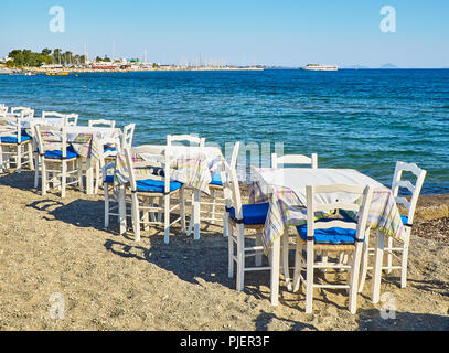 Tische und Stühle für eine griechische Taverne in der Nähe des Meeres in einem Strand der Insel Kos, Griechenland. Stockfoto