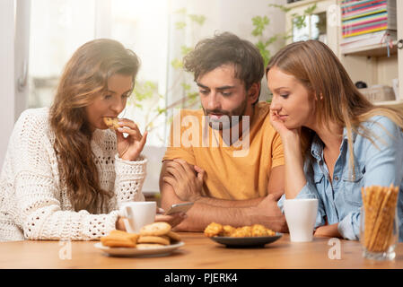 Gruppe von Freunden Sie Inhalt auf dem Smartphone. Freunde verbringt freie Zeit zu Hause. Stockfoto