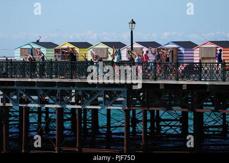 Hastings, East Sussex, UK. 7. Sep 2018. UK Wetter: Hell und sonnig in der Küstenstadt Hastings in East Sussex. Temperaturen von 20 °C sind mit kühlen Winde aus dem Westen erwartet. Eine große Gruppe von Menschen, die Yoga am Hastings Pier. © Paul Lawrenson 2018, Foto: Paul Lawrenson/Alamy leben Nachrichten Stockfoto