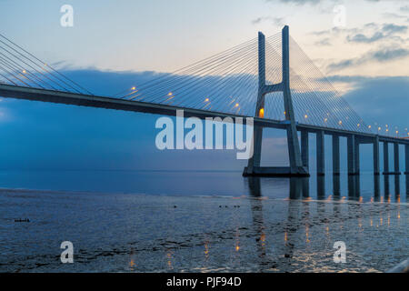 Amazing sunrise in der Vasco da Gama Brücke in Lissabon. Landschaft einer der Hauptattraktionen von Portugal, eine der längsten Brücken der Welt. Stockfoto